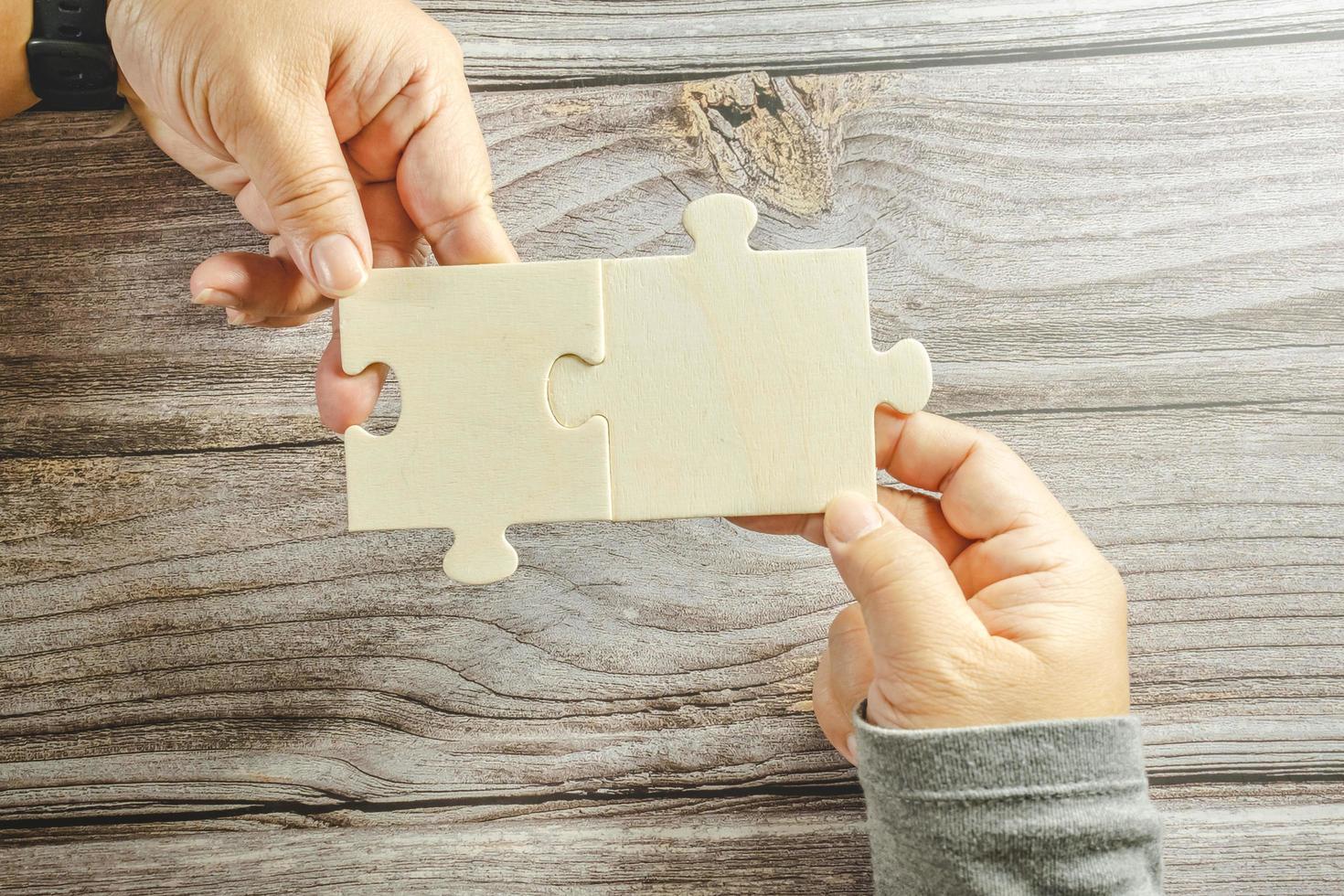 White jigsaw puzzle connecting together. Team business success partnership or teamwork concept. A group of business people assembling jigsaw puzzle. Business solutions, success and strategy concept. photo