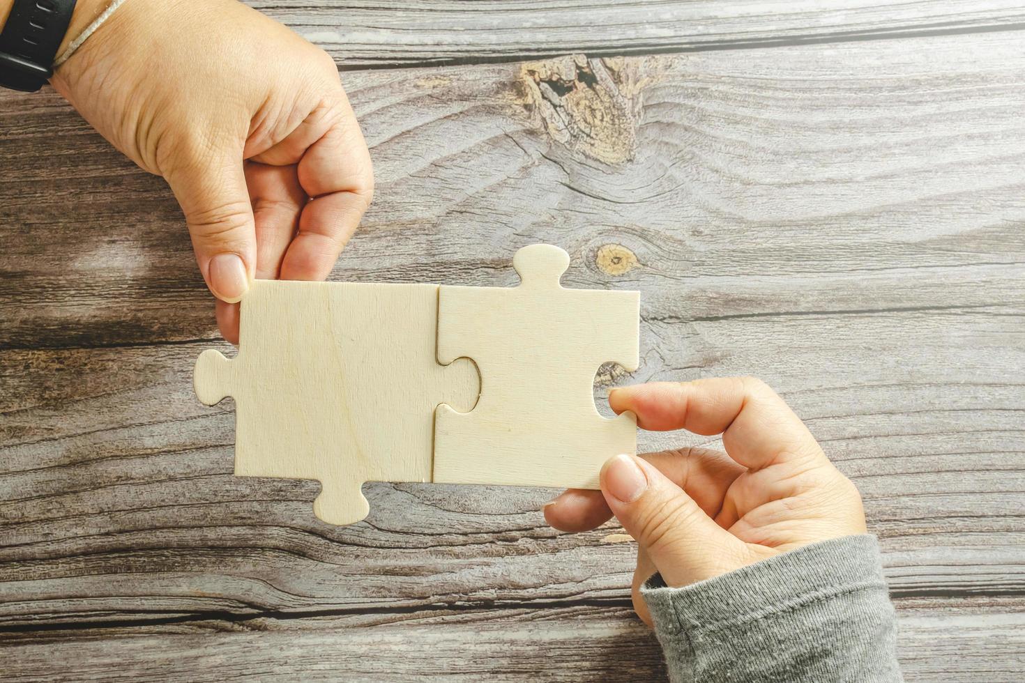 White jigsaw puzzle connecting together. Team business success partnership or teamwork concept. A group of business people assembling jigsaw puzzle. Business solutions, success and strategy concept. photo