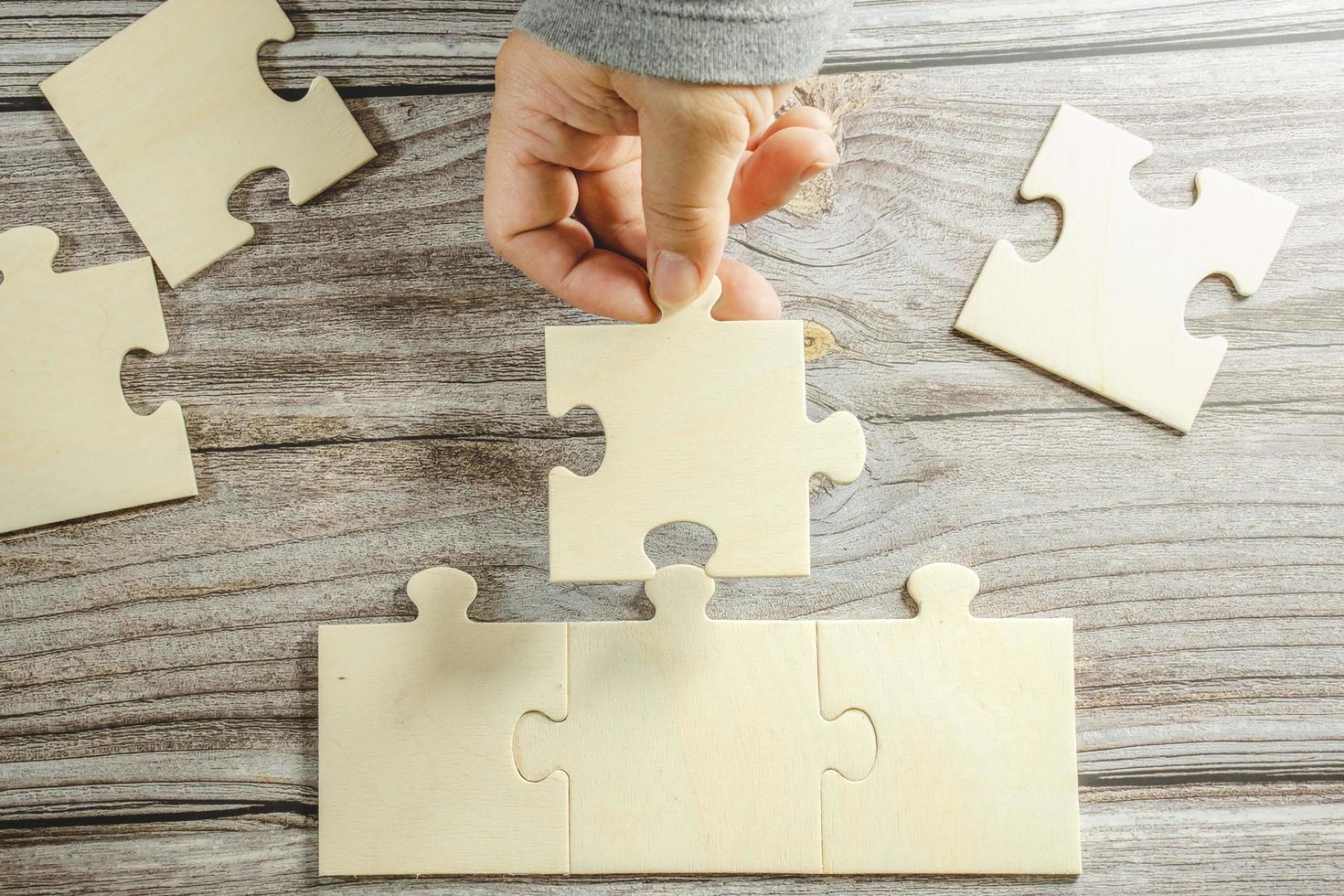 White jigsaw puzzle connecting together. Team business success partnership or teamwork concept. A group of business people assembling jigsaw puzzle. Business solutions, success and strategy concept. photo