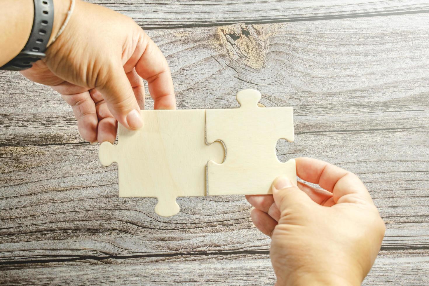 White jigsaw puzzle connecting together. Team business success partnership or teamwork concept. A group of business people assembling jigsaw puzzle. Business solutions, success and strategy concept. photo