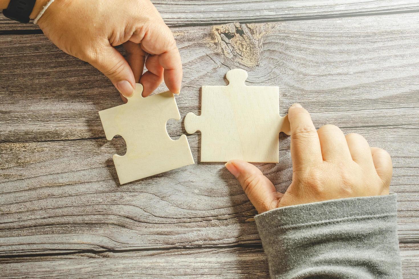 White jigsaw puzzle connecting together. Team business success partnership or teamwork concept. A group of business people assembling jigsaw puzzle. Business solutions, success and strategy concept. photo