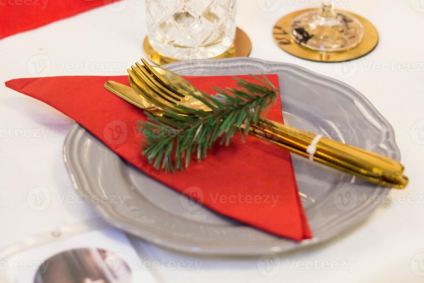 Christmas plate and goldware with red cloth with branch of fir tree photo