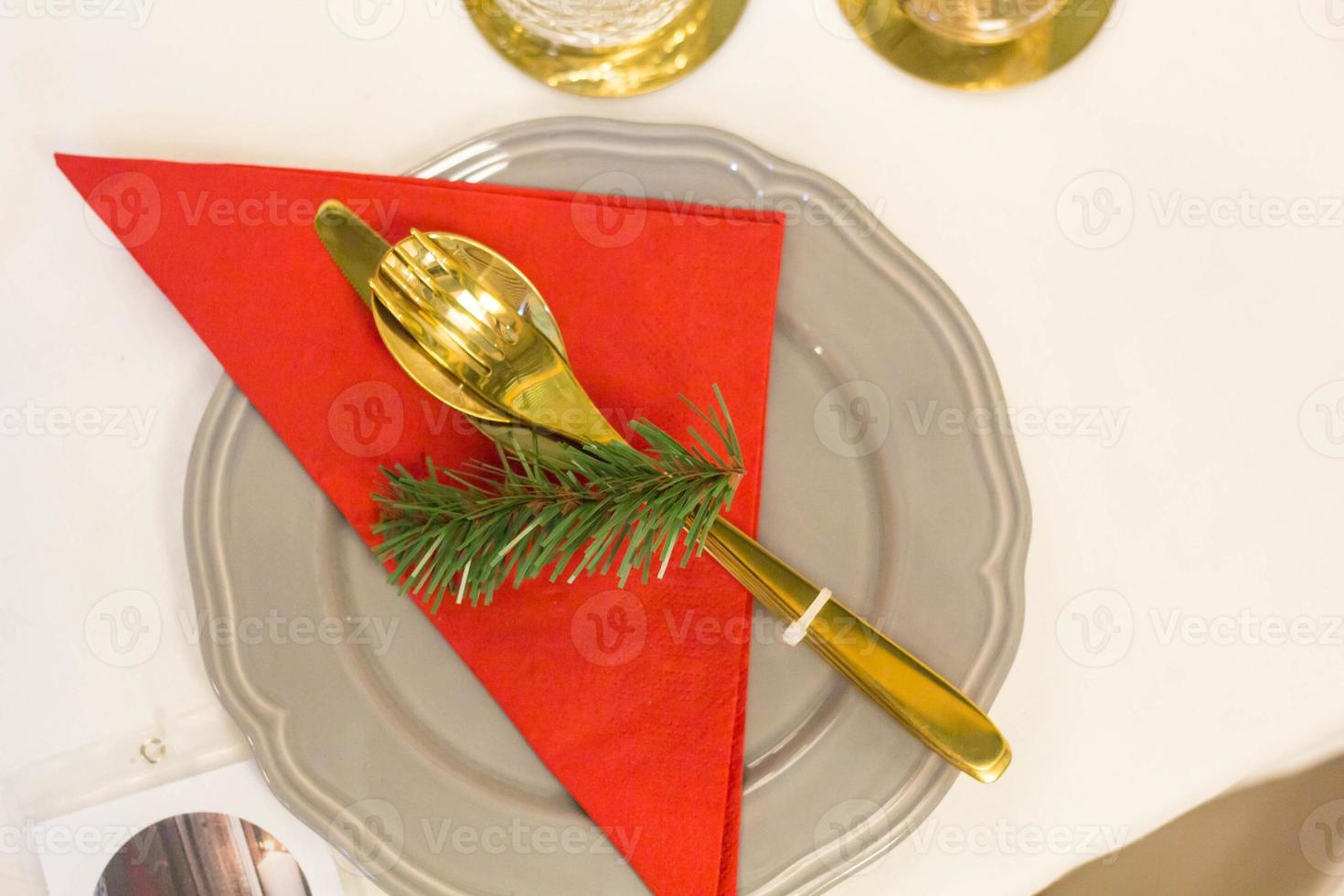 Christmas plate and goldware with red cloth with branch of fir tree photo