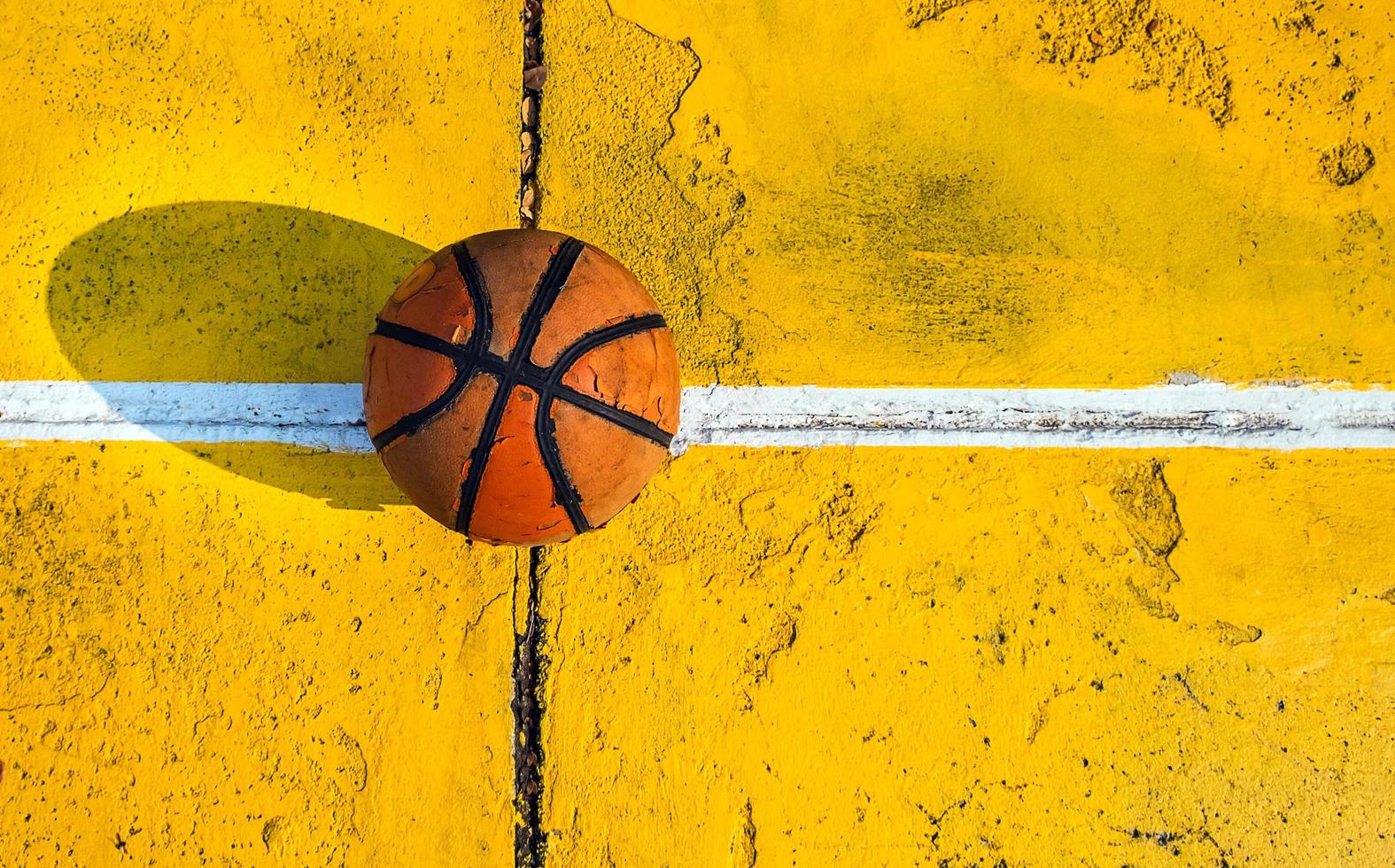 Top view of Old basketball that have already been used in the yellow basketball court. photo