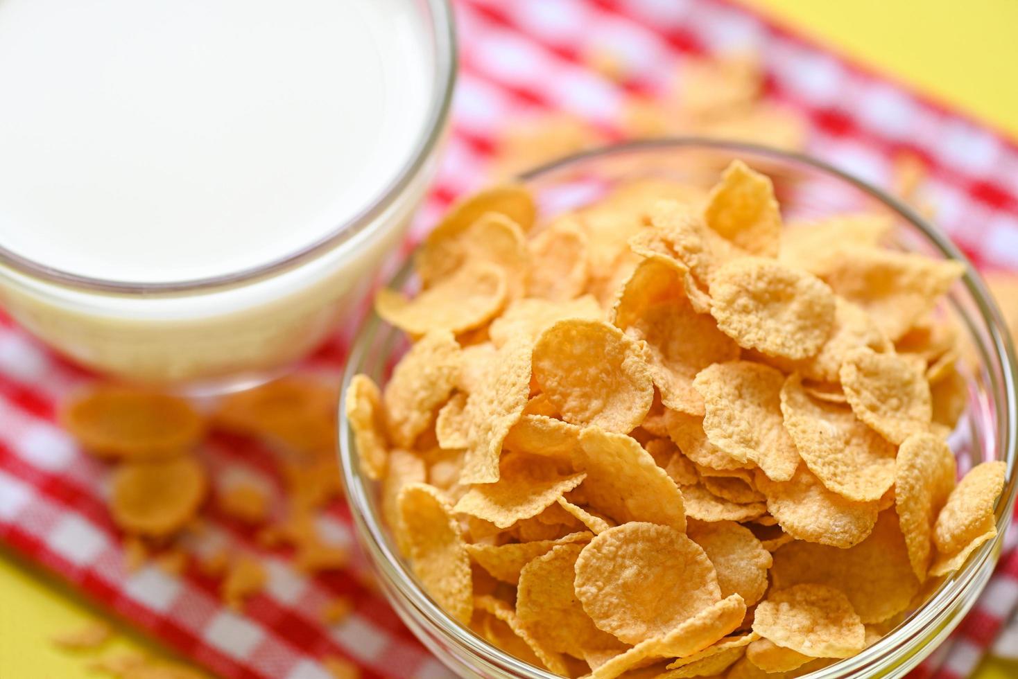 tazón de copos de maíz desayuno y merienda para un concepto de comida saludable, desayuno matutino cereal integral fresco, copos de maíz con leche sobre fondo amarillo foto