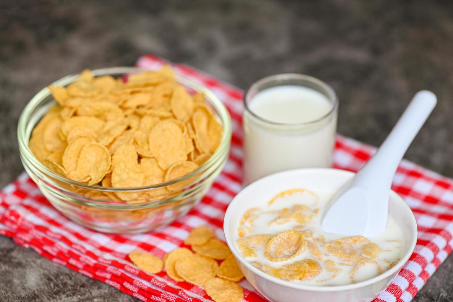cornflakes bowl breakfast food and snack for healthy food concept, morning breakfast fresh whole grain cereal, cornflakes with milk on dark background photo