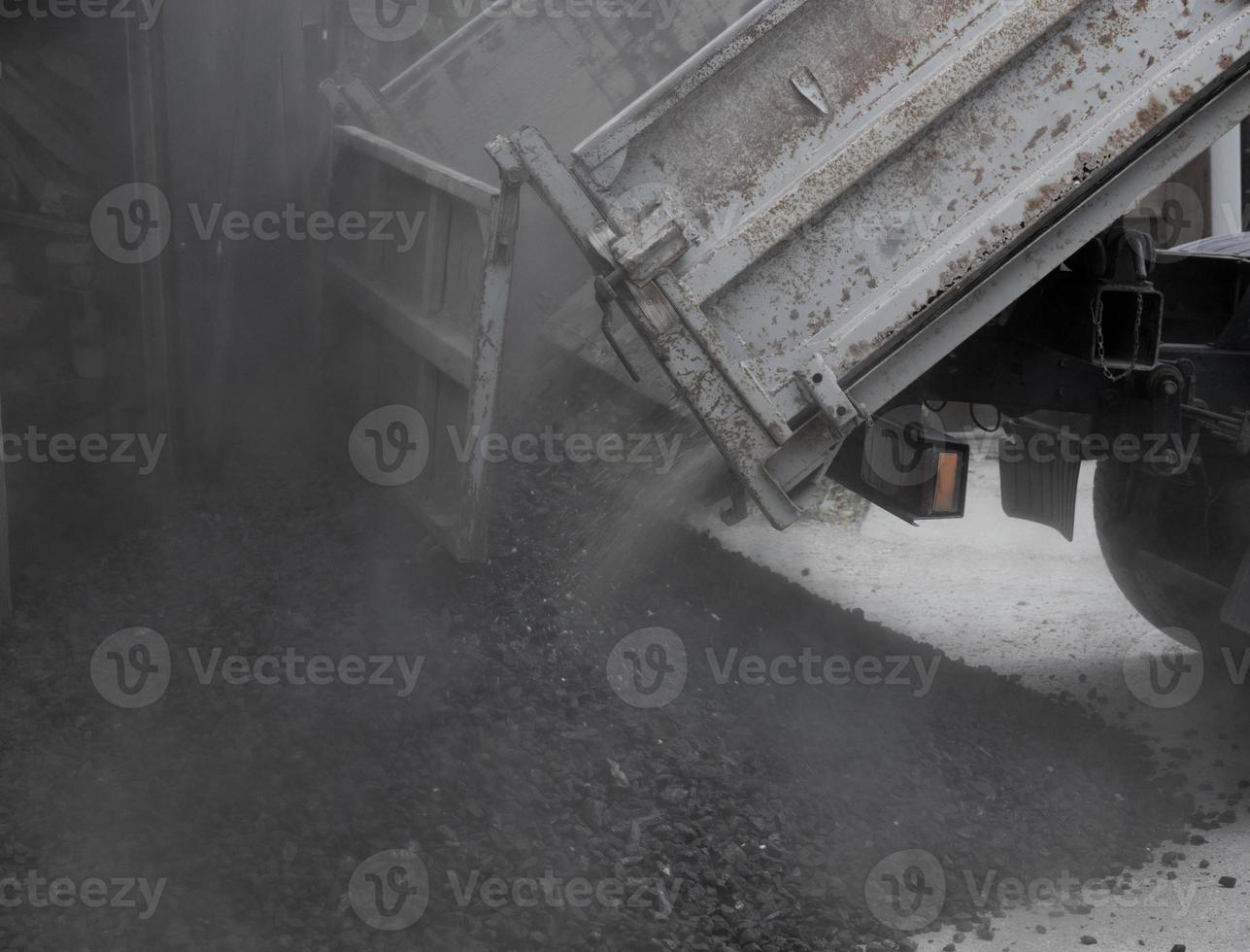 A truck unloads black coal into the street. Energy crisis. Soft focus. photo