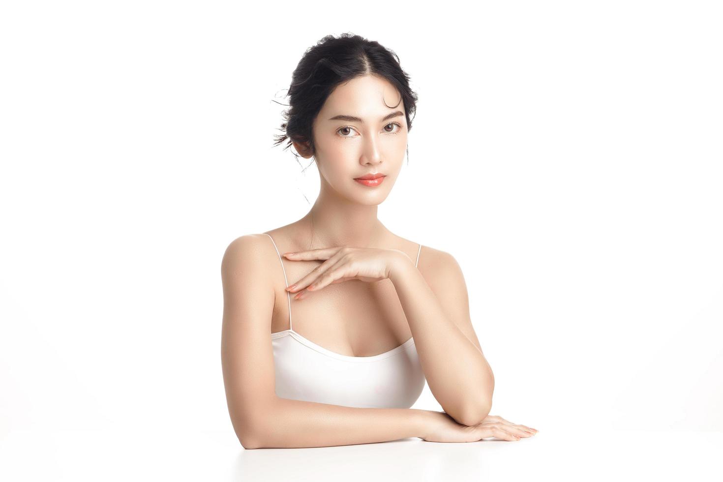 Asian woman with a beautiful face and Perfect clean fresh skin. Cute female model with natural makeup and sparkling eyes on white isolated background. Facial treatment, Cosmetology, beauty Concept. photo