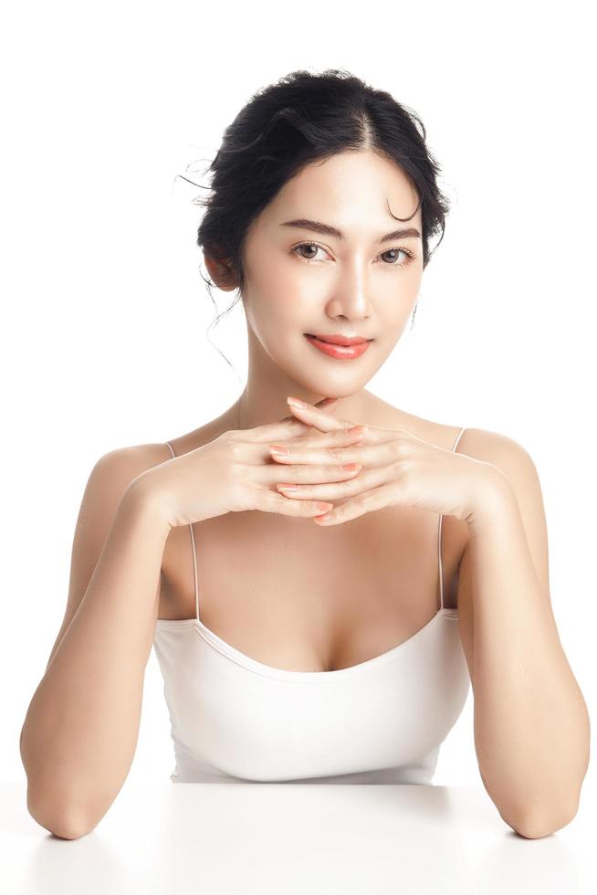 Asian woman with a beautiful face and Perfect clean fresh skin. Cute female model with natural makeup and sparkling eyes on white isolated background. Facial treatment, Cosmetology, beauty Concept. photo