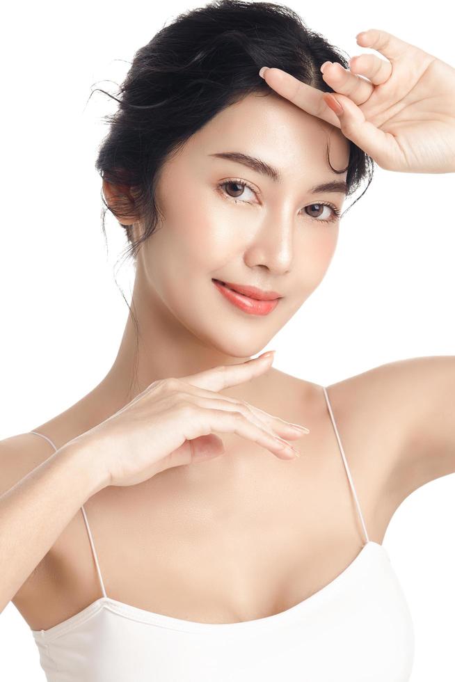 Asian woman with a beautiful face and Perfect clean fresh skin. Cute female model with natural makeup and sparkling eyes on white isolated background. Facial treatment, Cosmetology, beauty Concept. photo