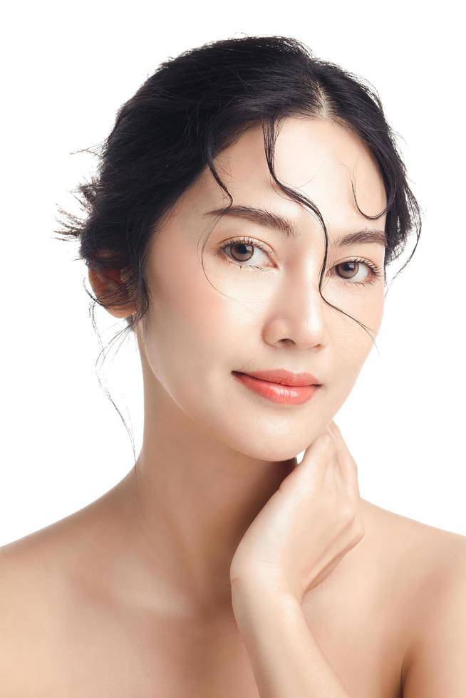 Asian woman with a beautiful face and Perfect clean fresh skin. Cute female model with natural makeup and sparkling eyes on white isolated background. Facial treatment, Cosmetology, beauty Concept. photo