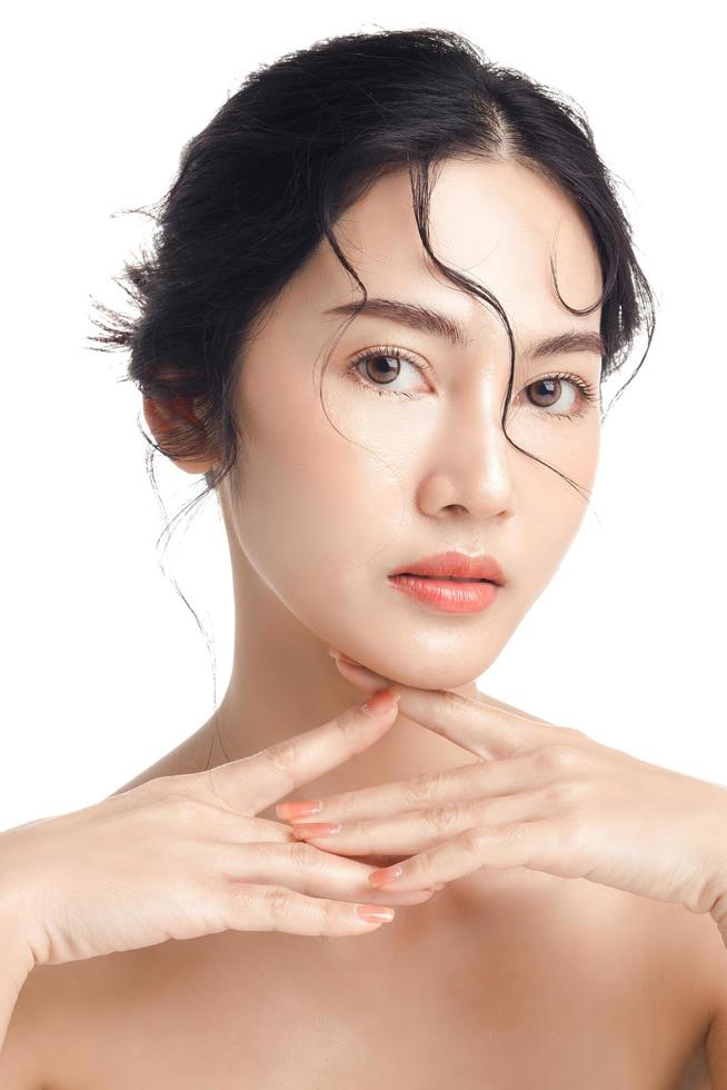 Asian woman with a beautiful face and Perfect clean fresh skin. Cute female model with natural makeup and sparkling eyes on white isolated background. Facial treatment, Cosmetology, beauty Concept. photo