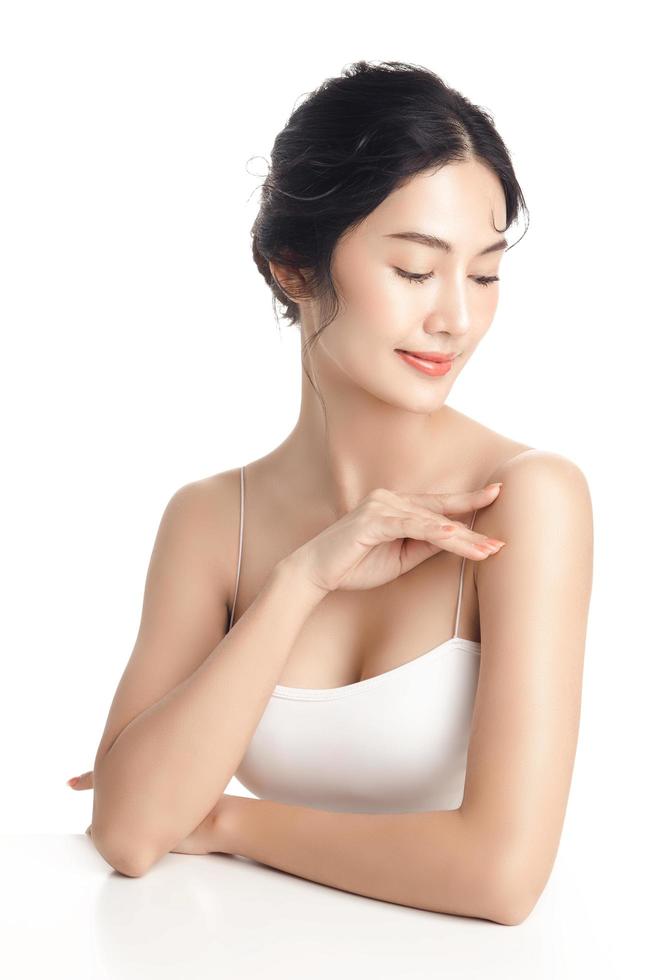 Asian woman with a beautiful face and Perfect clean fresh skin. Cute female model with natural makeup and sparkling eyes on white isolated background. Facial treatment, Cosmetology, beauty Concept. photo