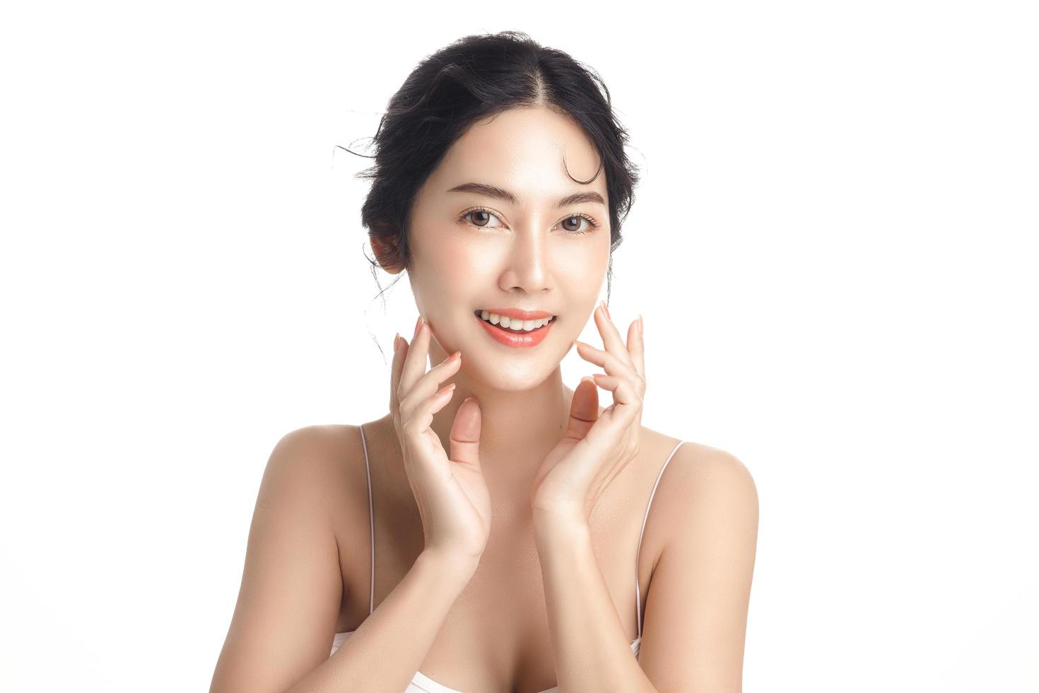 Asian woman with a beautiful face and Perfect clean fresh skin. Cute female model with natural makeup and sparkling eyes on white isolated background. Facial treatment, Cosmetology, beauty Concept. photo