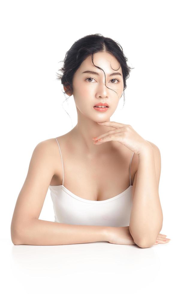 Asian woman with a beautiful face and Perfect clean fresh skin. Cute female model with natural makeup and sparkling eyes on white isolated background. Facial treatment, Cosmetology, beauty Concept. photo