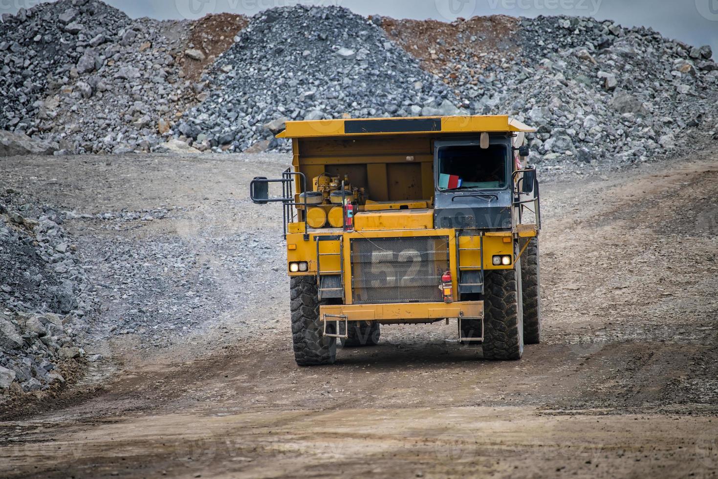 Work of trucks and the excavator in an open pit on gold mining photo