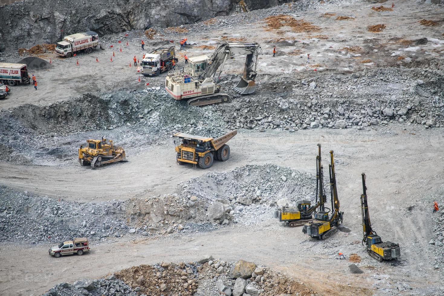 Work of trucks and the excavator in an open pit on gold mining photo