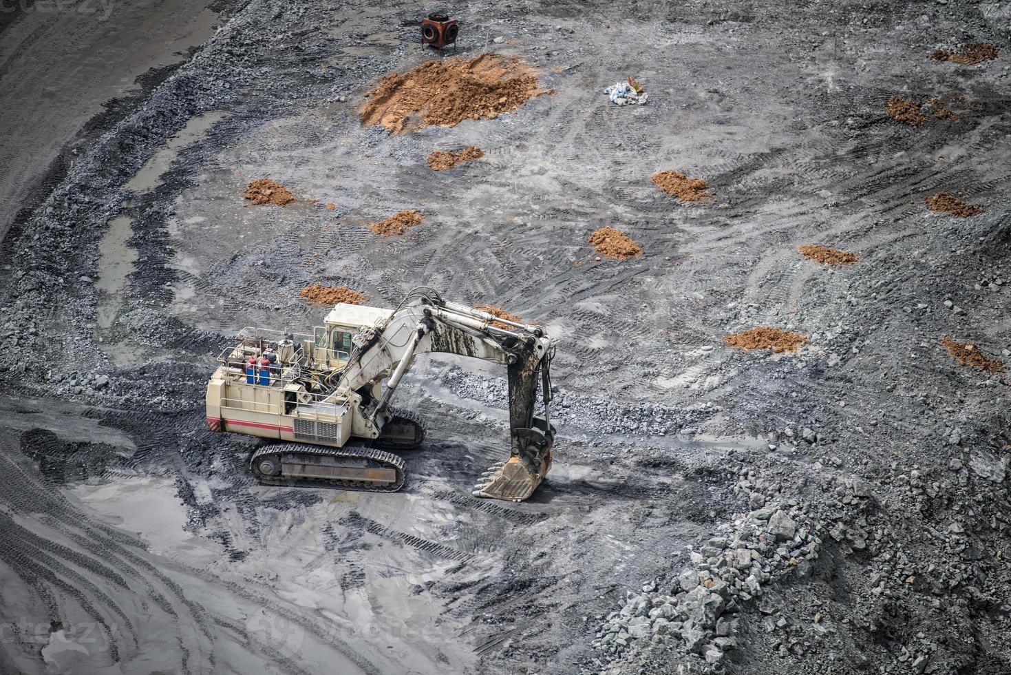 Work of trucks and the excavator in an open pit on gold mining photo