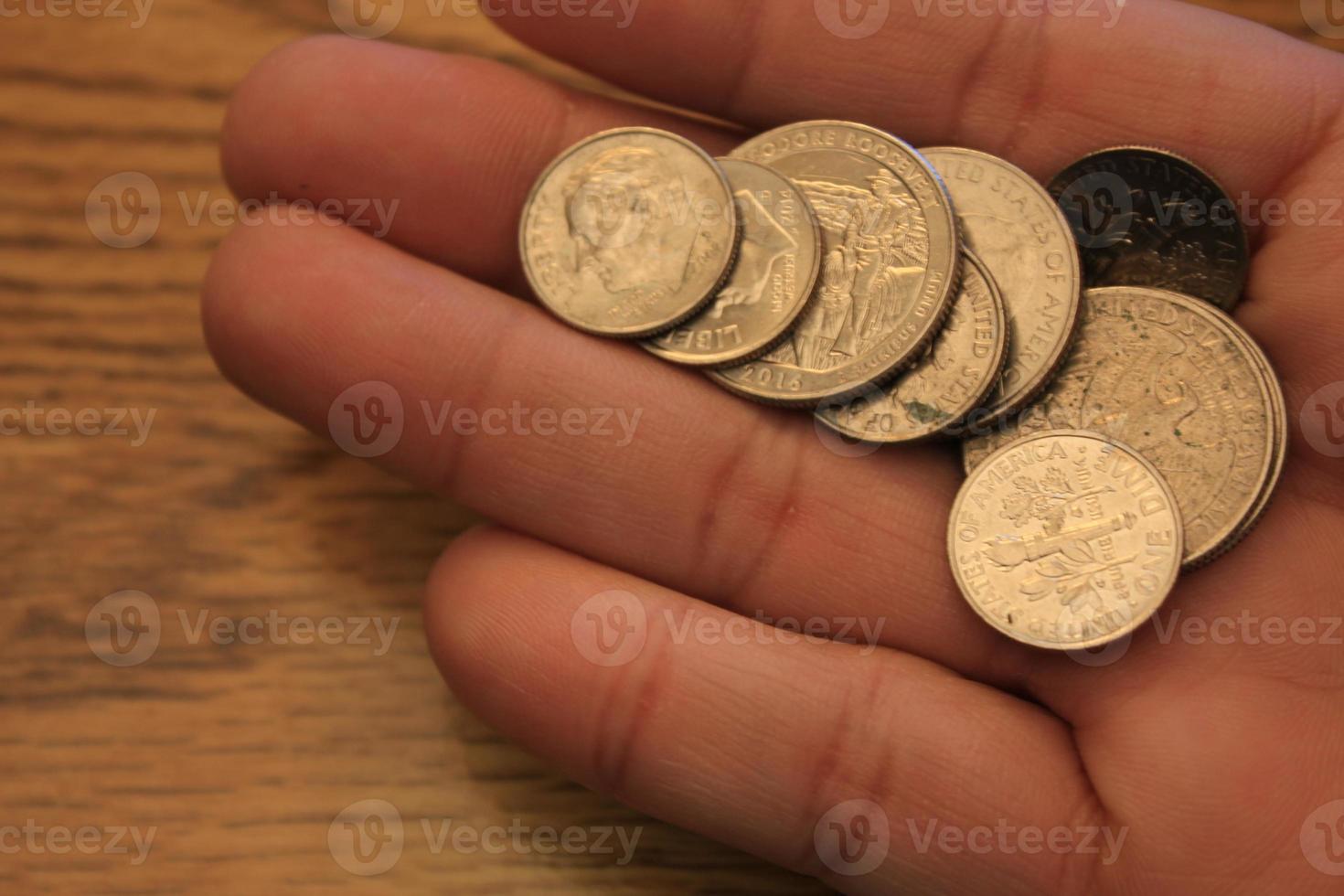 Quarters and Dime coins are the currency of America. In the hands of men. photo