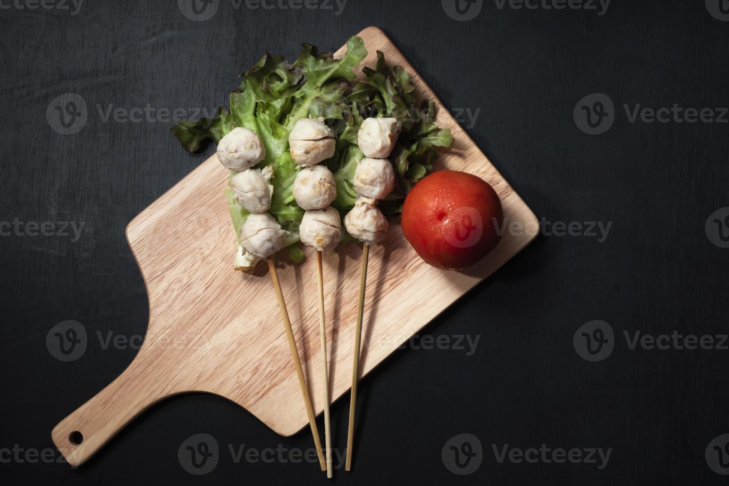 Meat ball in cutting board on black wood background. photo