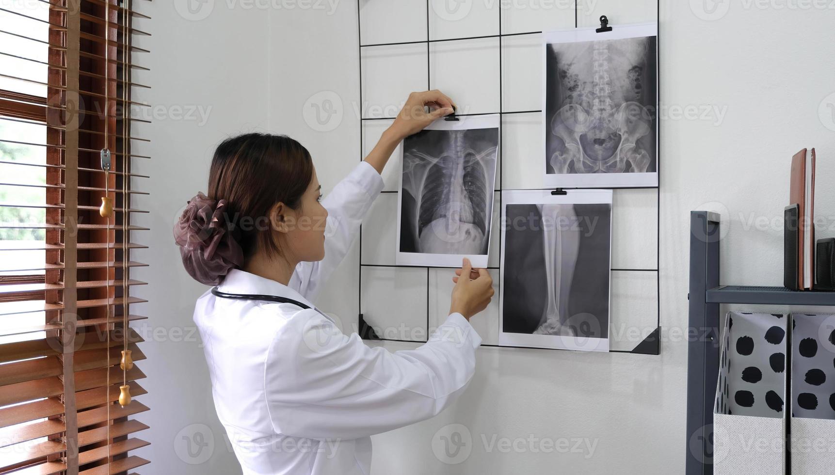 médico que muestra el resultado de la radiografía al paciente en la clínica. foto
