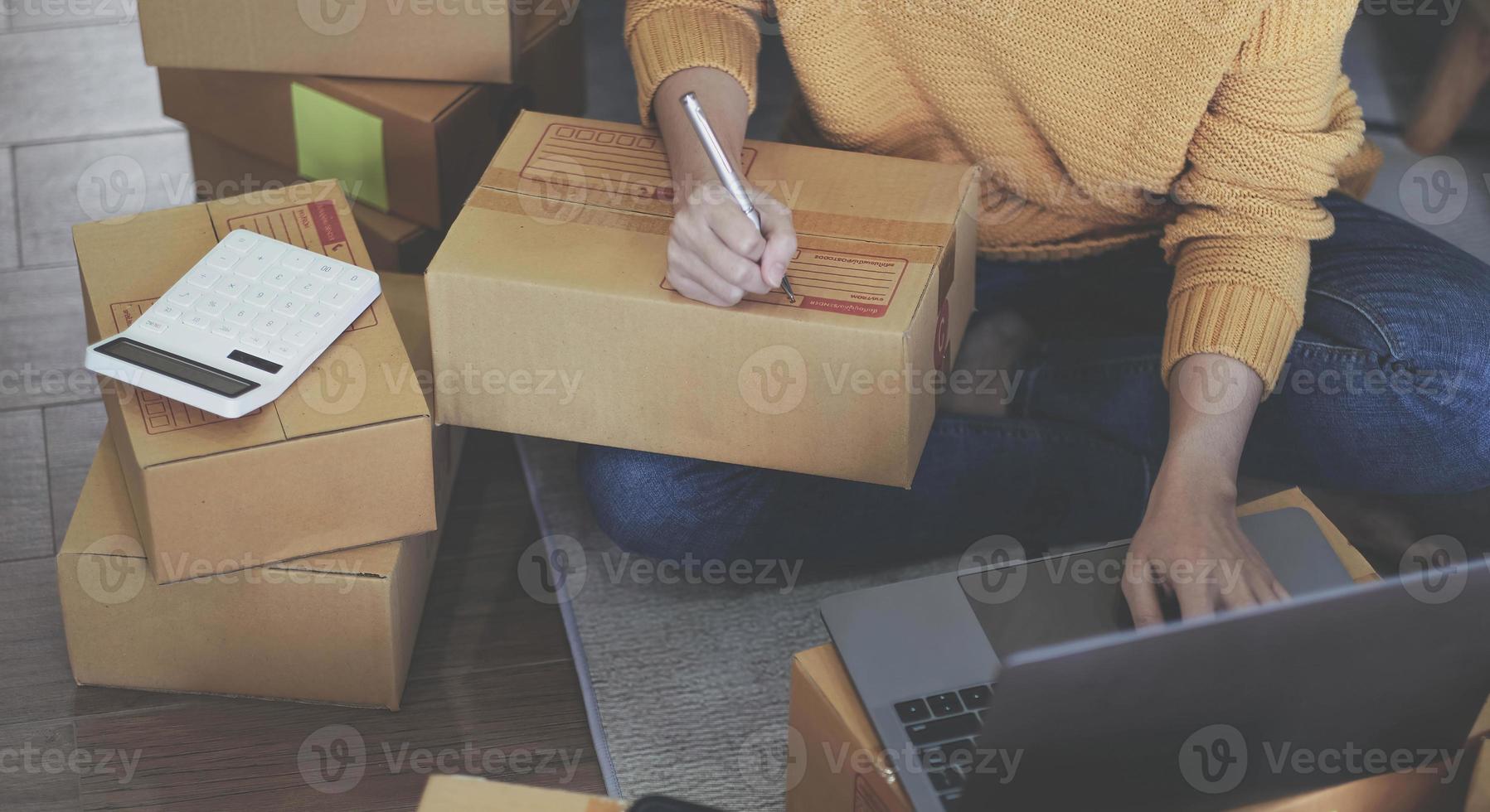 Startup Entrepreneurship Small Business SME Freelance Young lady working at home with boxes on the floor and laptop online Marketing Packaging SME Shipping Ecommerce Concepts photo