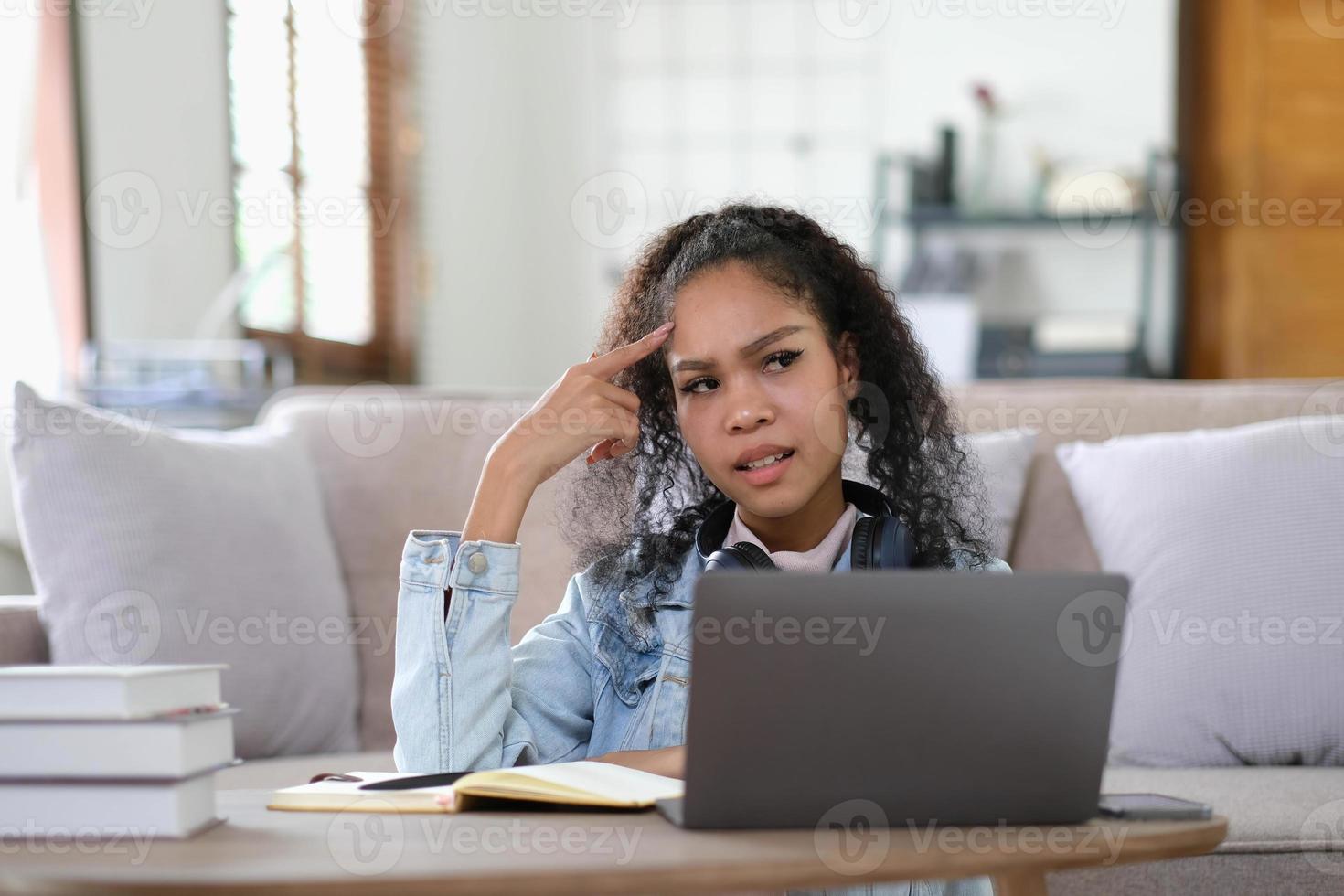 Exhausted female student feeling headache from problems with university course work connected to wifi for browsing informative websites, unhappy dark skinned woman tired from e learning on laptop photo