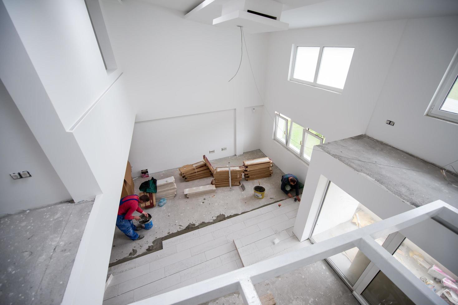 worker installing the ceramic wood effect tiles on the floor photo