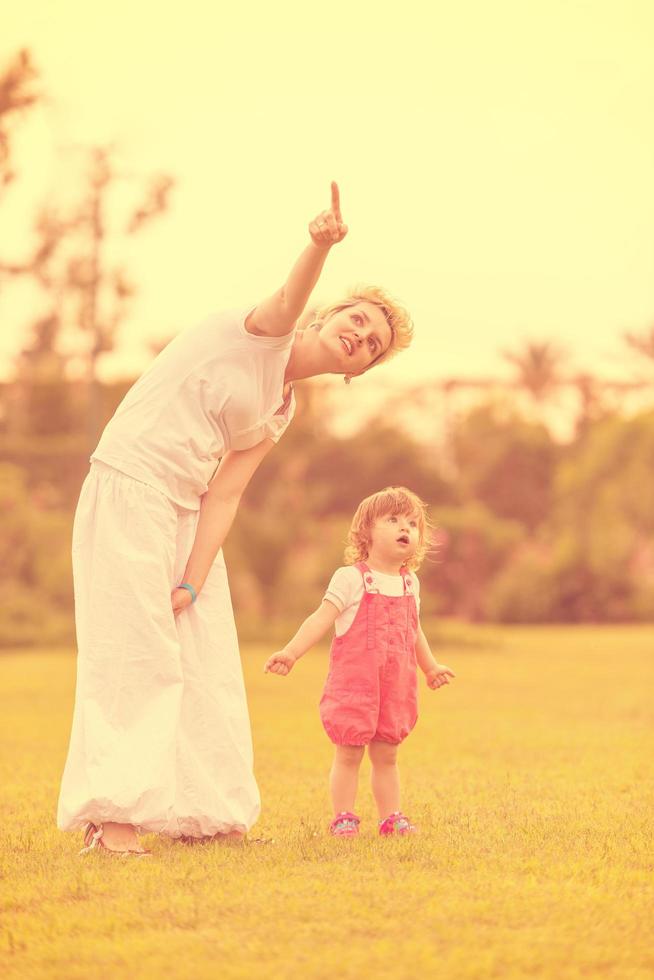 mother and little daughter playing at backyard photo