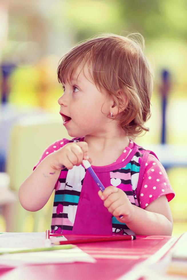 little girl drawing a colorful pictures photo