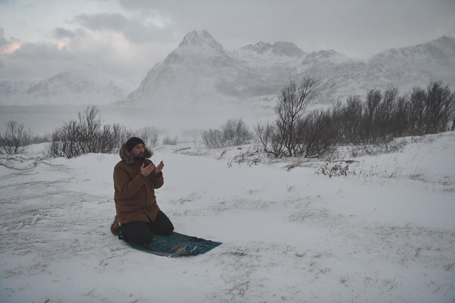 viajero musulmán rezando en el frío día de invierno nevado foto