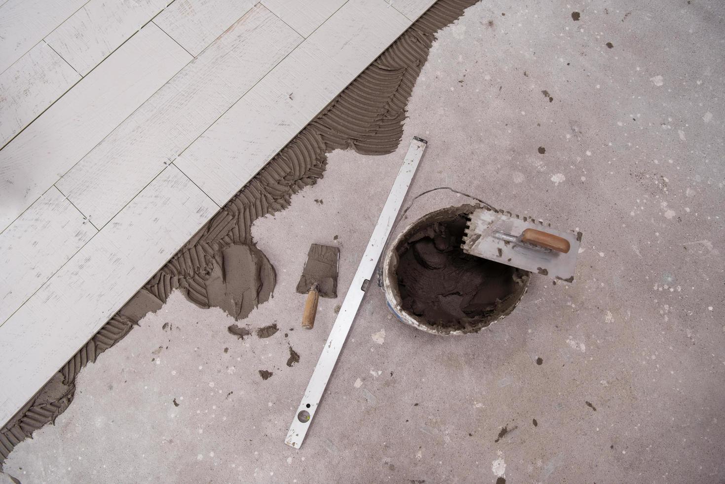 Ceramic wood effect tiles and tools for tiler on the floor photo