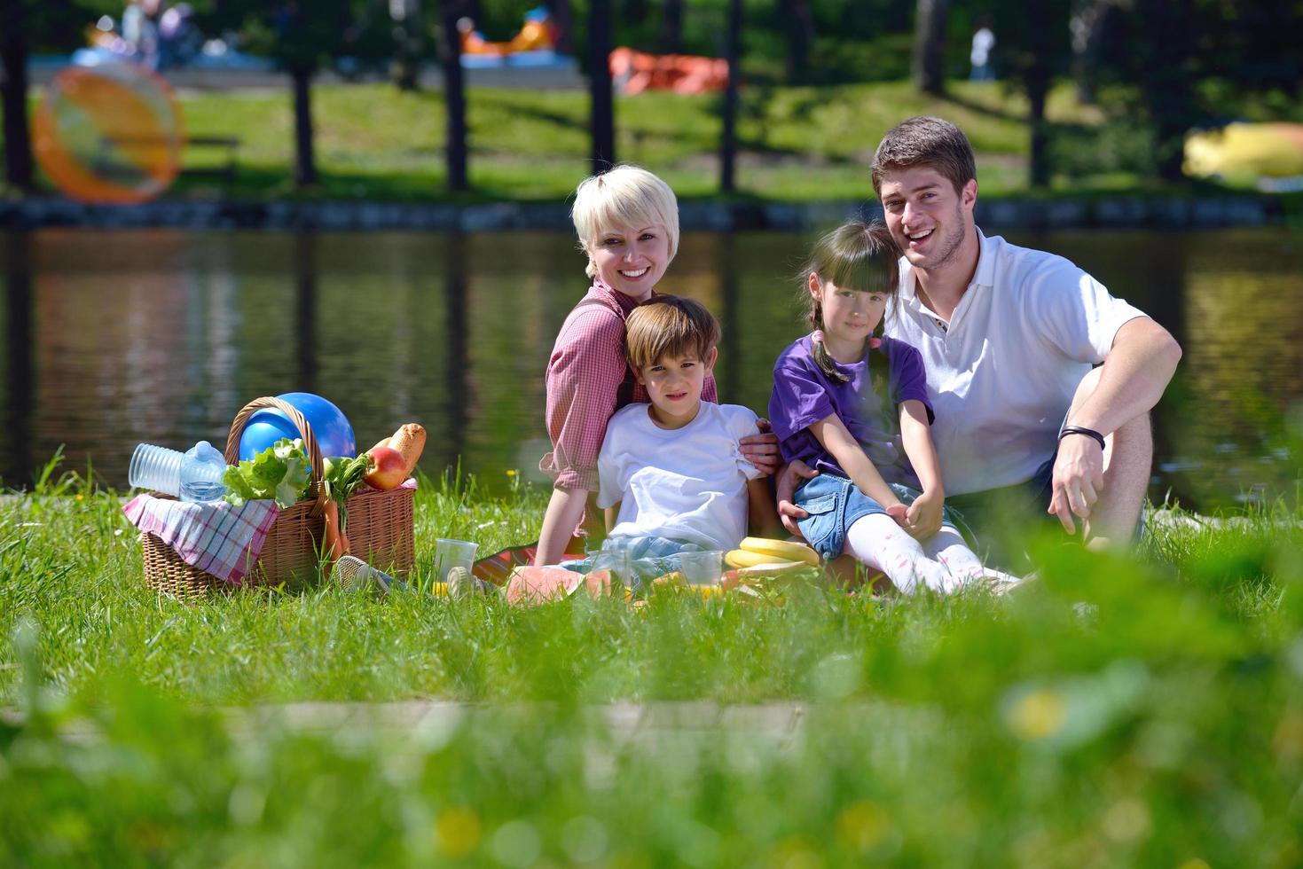 Happy family playing together in a picnic outdoors photo