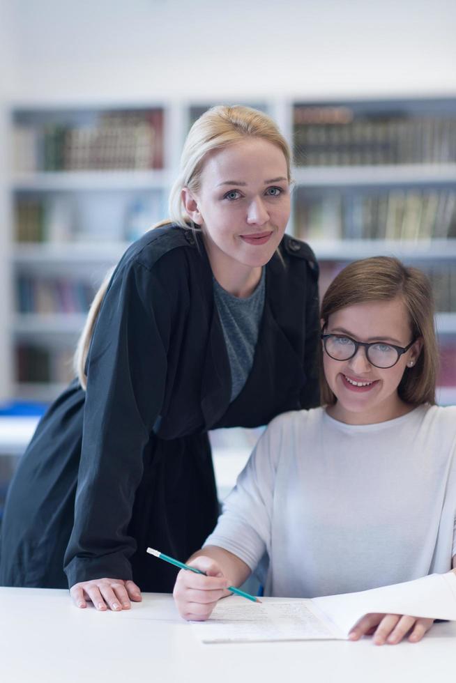 female teacher helping students on class photo