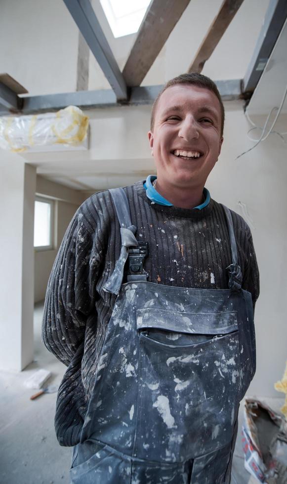 retrato de trabajador de la construcción con uniforme sucio en apartamento foto