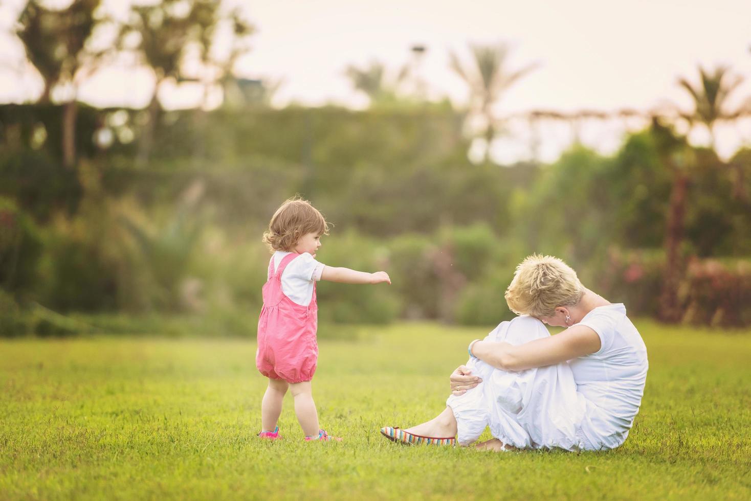 mother and little daughter playing at backyard photo