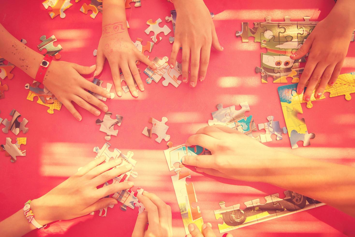 top view of kids hands playing with puzzles photo