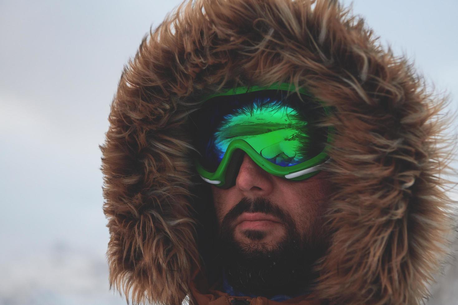 man at winter in stormy weather wearing warm  fur jacket photo