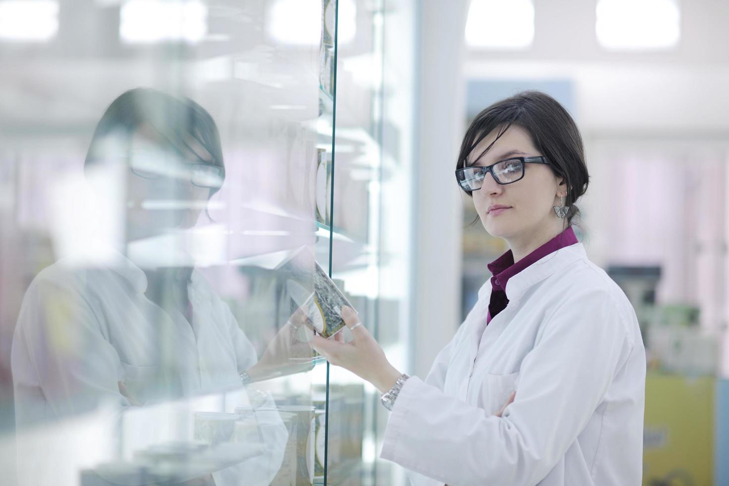 Farmacéutico químico mujer de pie en farmacia droguería foto