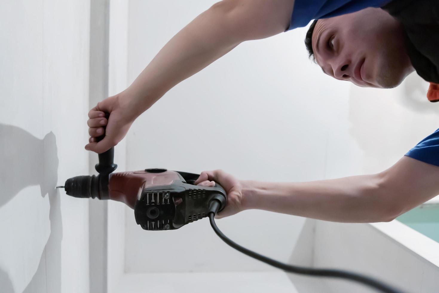 construction worker drilling holes in the bathroom photo