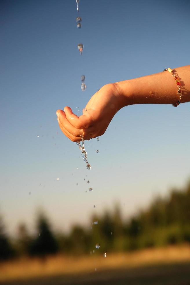 fresh water falling on children hands photo