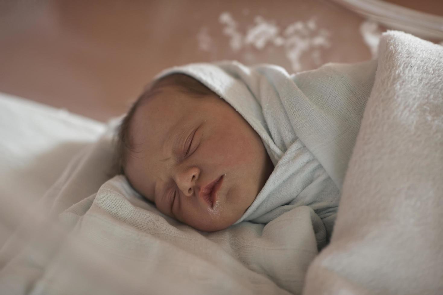 newborn baby sleeping in  bed at hospital photo