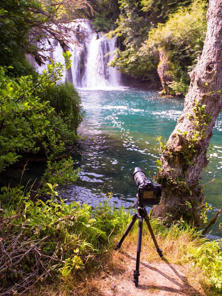 profesional DSLR camera on a tripod at beautiful waterfall photo
