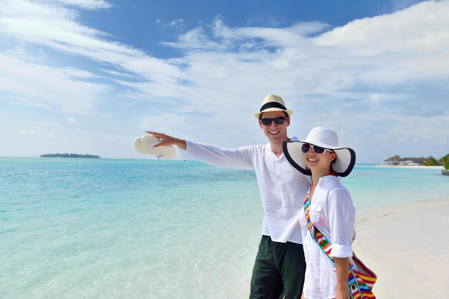 feliz pareja joven divertirse en la playa foto