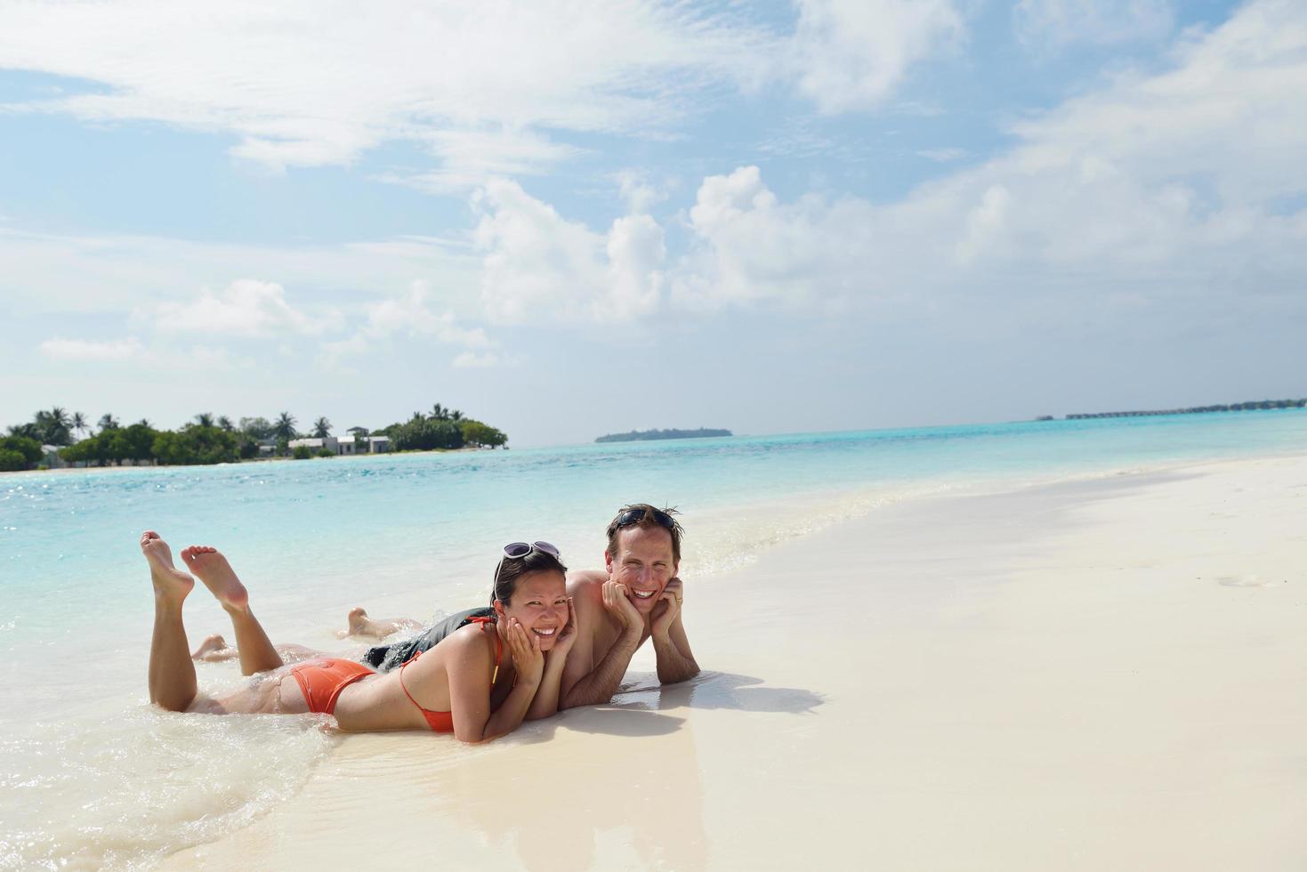 happy young couple have fun on beach photo