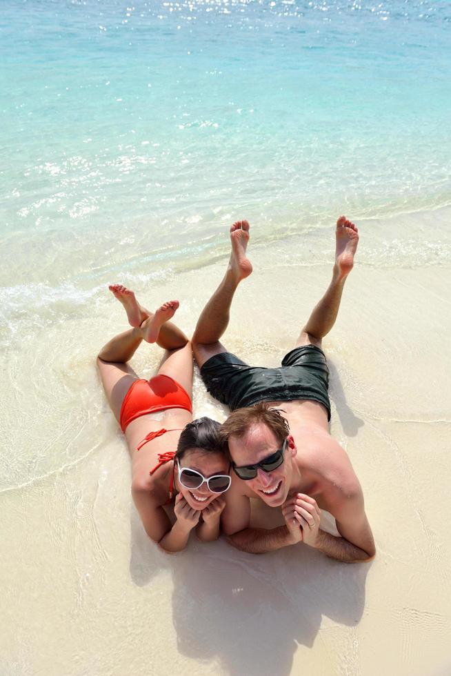 feliz pareja joven divertirse en la playa foto