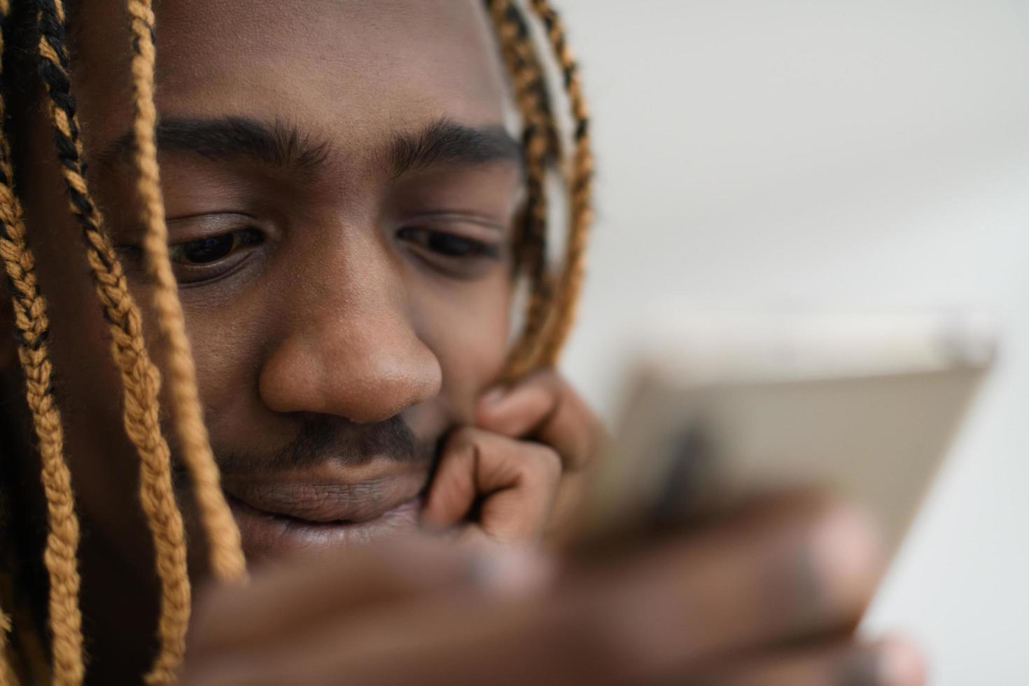 afro guy uses a cell phone and browses social media during a pandemic photo