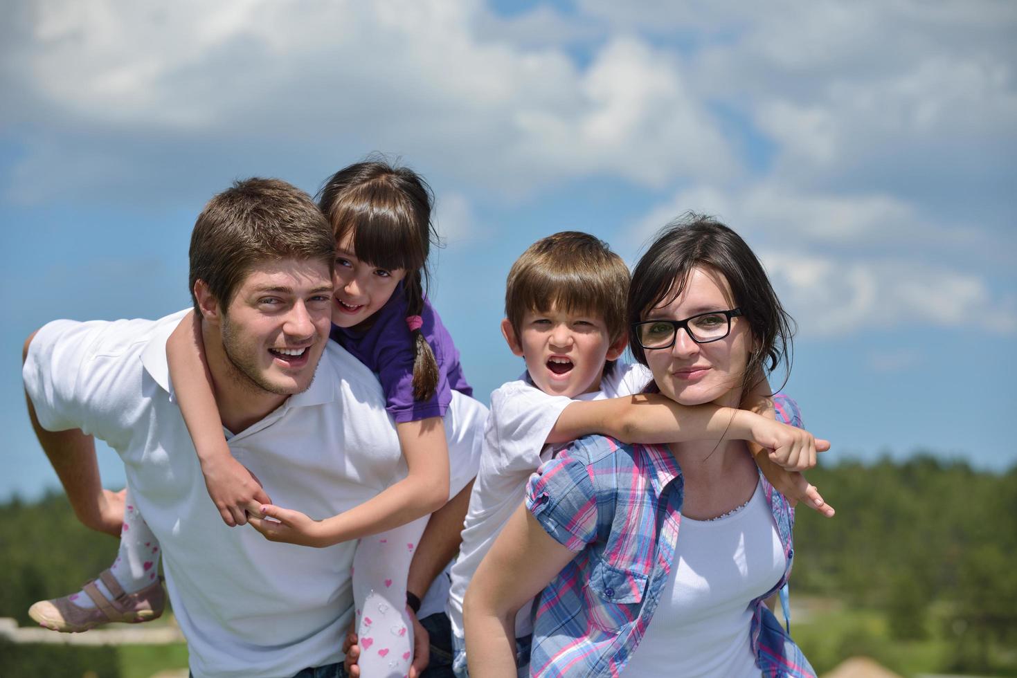 familia joven feliz divertirse al aire libre foto