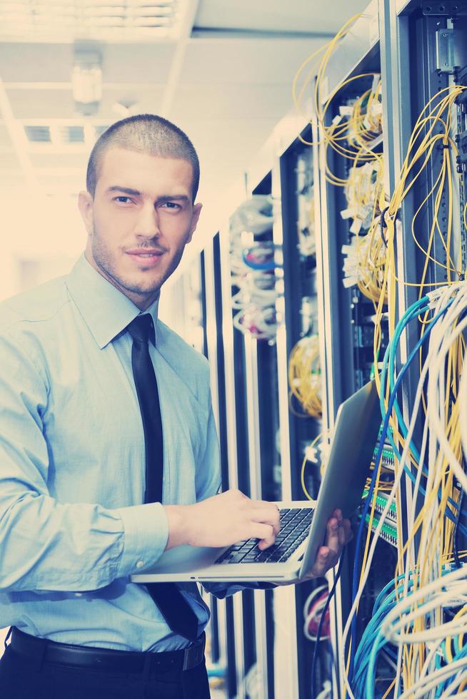 businessman with laptop in network server room photo