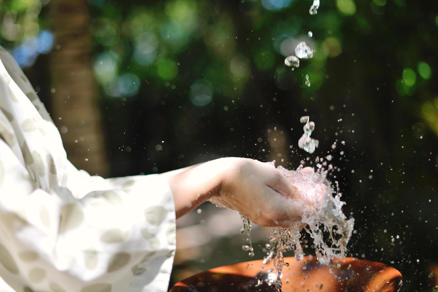 salpicando agua dulce en manos de mujer foto